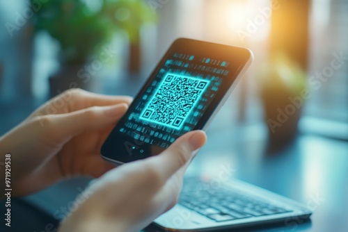 Scanning QR code on smartphone near laptop