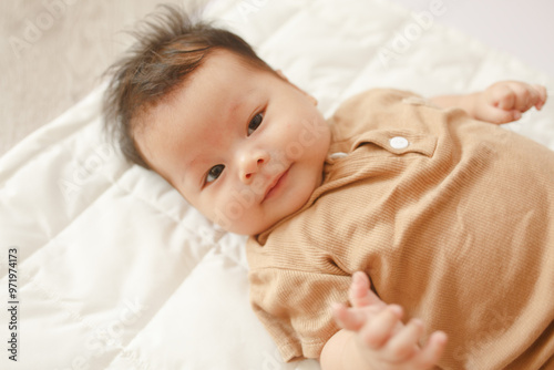 a baby laying on top of a white blanket photo