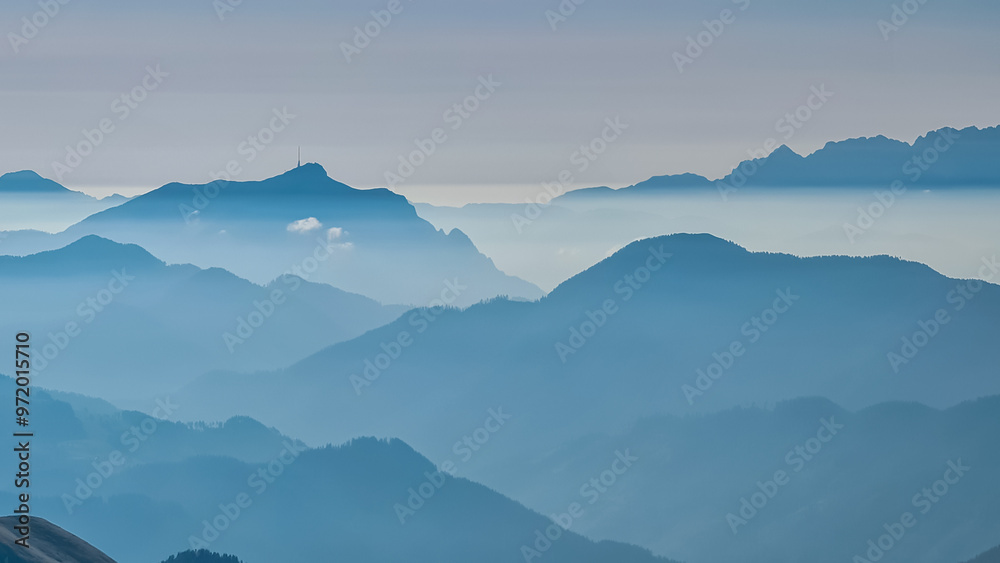 Fototapeta premium Serene alpine landscape at dawn in Gailtal Alpen, Carinthia, Austria, Europe. Silhouette of majestic hazy mountain ridges of Julian Alps. Peaceful tranquil atmosphere in Austrian Alps. Wanderlust