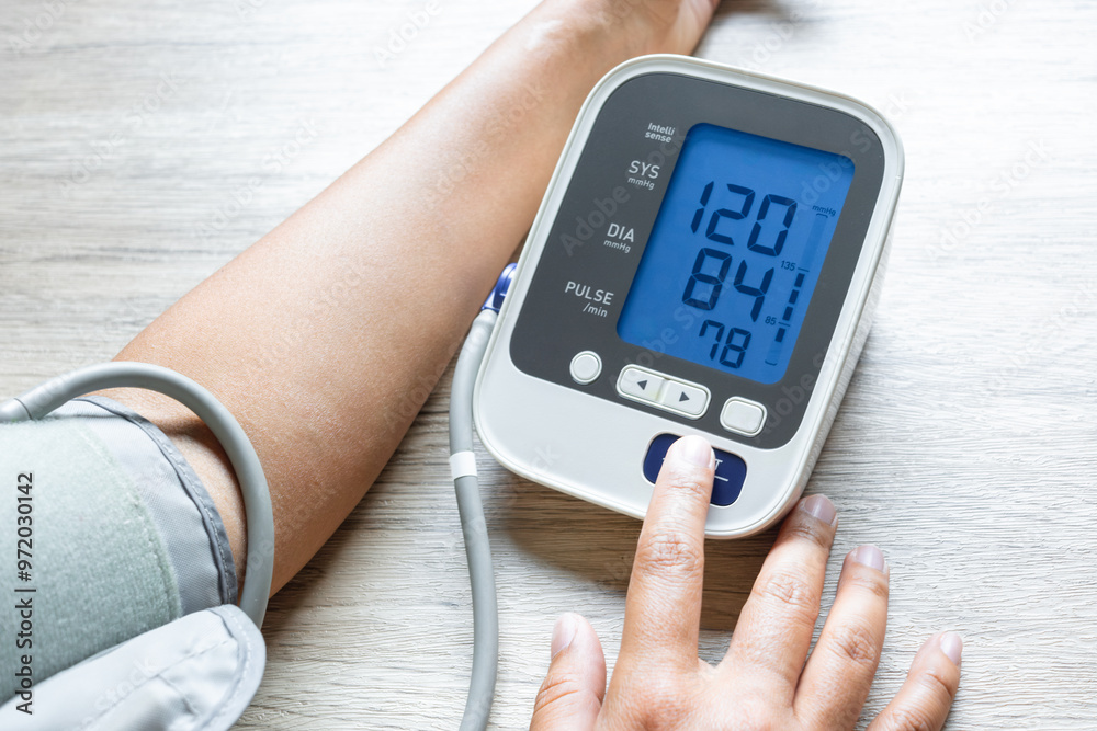 Man checks blood pressure monitor and heart rate monitor with digital pressure gauge. Health care and Medical concept Man checks blood pressure monitor and heart rate monitor with digital pressure gauge. Health care and Medical concept