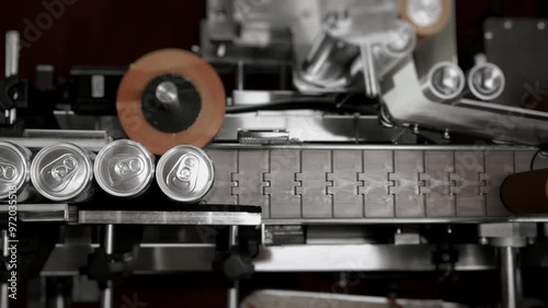 Production line for bottling drinks and beer at the plant. Filled aluminum cans move along a conveyor for packaging. Aluminum cans without logos for drinks. Beverage production and bottling plant.
