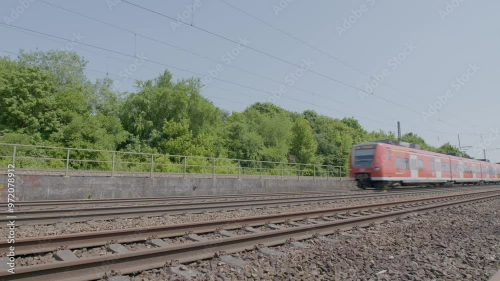 Red train speeding past in a rural area on a sunny day, side view Red train speeding past in a rural area on a sunny day, side view