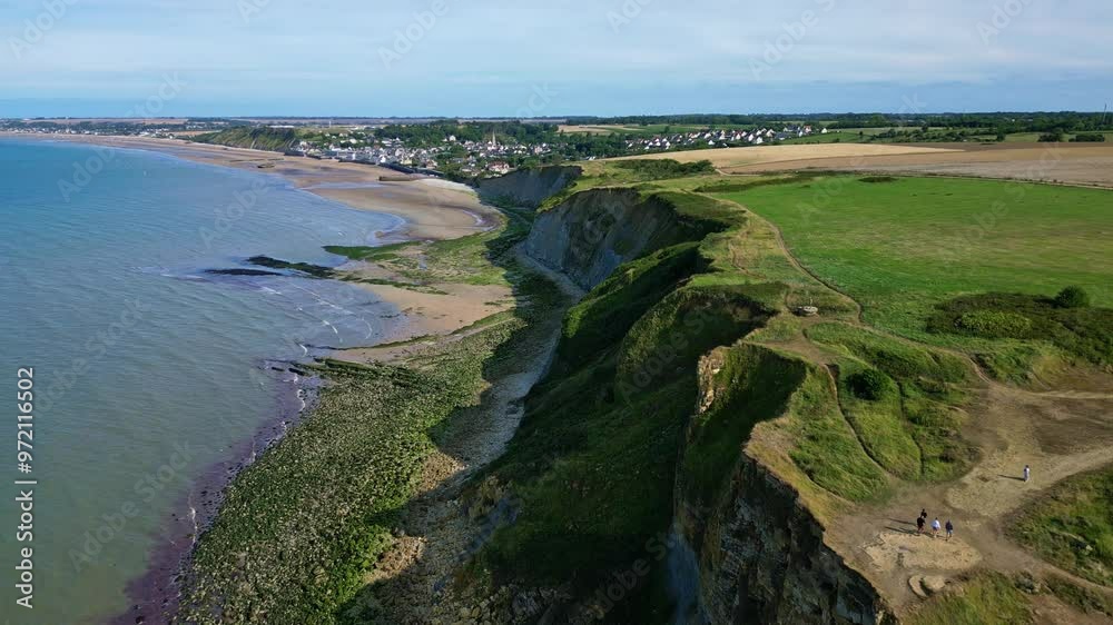 Arromanches-les-Bains rocky shoreline, Normandie, France. Aerial drone descending forward Arromanches-les-Bains rocky shoreline, Normandie, France. Aerial drone descending forward