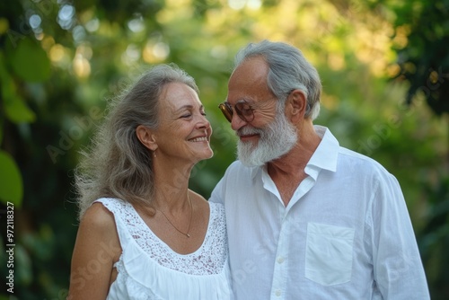 Retired couple in white  smiling together outdoors. photo