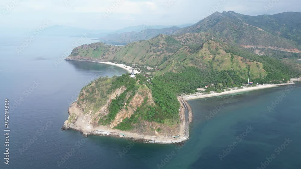 A coastal peninsula with green hills and blue water in timor-leste during the day, aerial view A coastal peninsula with green hills and blue water in timor-leste during the day, aerial view