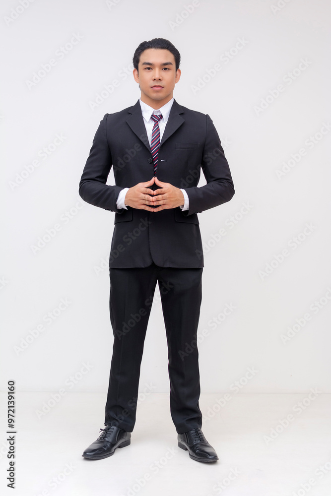 A confident young asian businessman stands in a formal black suit and tie, exuding professionalism and focus. Hands together as if to propose. Isolated on a white background. A confident young asian businessman stands in a formal black suit and tie, exuding professionalism and focus. Hands together as if to propose. Isolated on a white background.