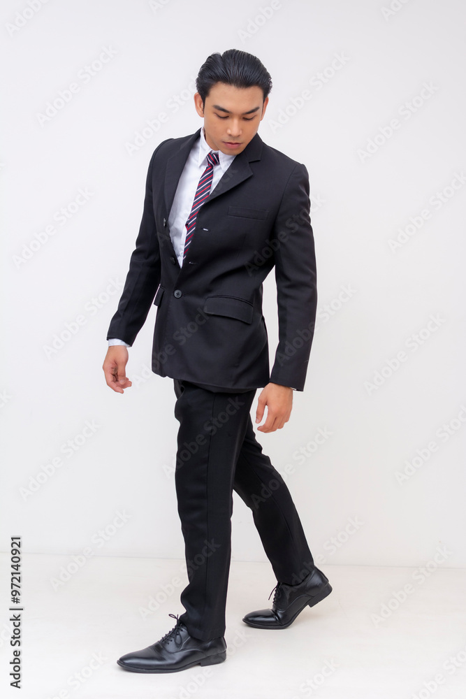 Full-body Portrait of a handsome asian businessman in a suit and tie, noticing something on the floor near his shoe. Isolated on a white background. Full-body Portrait of a handsome asian businessman in a suit and tie, noticing something on the floor near his shoe. Isolated on a white background.