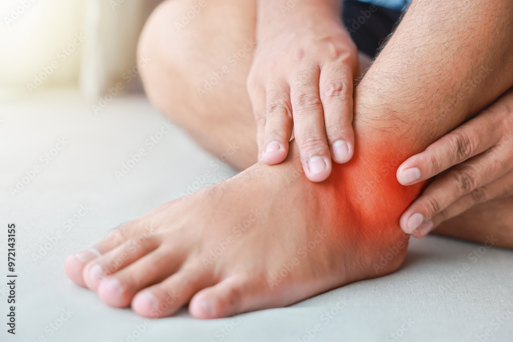 A man injured his ankle and it was swollen and red. Causes of pain include Ankle sprain, Gout, Rheumatoid arthritis, office syndrome, numbness, and cramp symptoms. Healthcare medical concept.