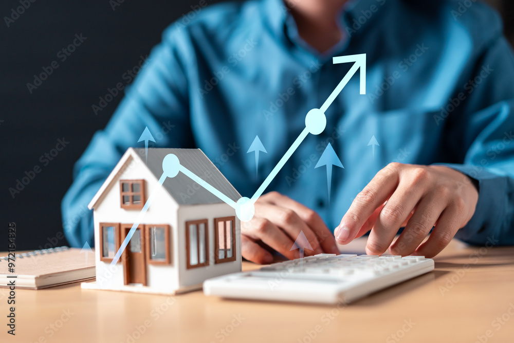 Fototapeta premium rent, residential, financial, rental, finance, investment, calculator, savings, estate, insurance. A man is typing on a keyboard in front of a house with a graph showing a rising line.