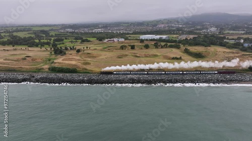 Steam Train, Ballynerrin, County Wicklow, Ireland, September 2024. Drone follows the Dublin Riviera Express pulled by No.131 Steam Locomotive south towards Wicklow town past Charlesland Golf Club. photo