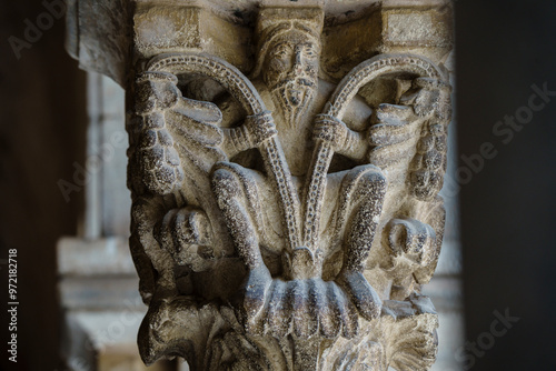 monastery of San Cugat del Vallés cloister, Floral decoration with a character capital, San Cugat del Vallés, Barcelona, ​​Catalonia, Spain photo