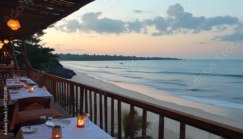 Dreamy beachfront terrace overlooking a serene beach at sunset, with tables elegantly set for dinner in a paradisiacal atmosphere photo