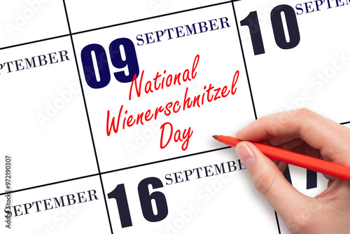 September 9. Hand writing text National Wienerschnitzel Day on calendar date. Save the date. photo