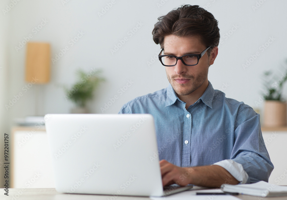 Serious Businessman Working At Laptop Computer Typing Something In Office. Business Career Concept. Copy Space Serious Businessman Working At Laptop Computer Typing Something In Office. Business Career Concept. Copy Space