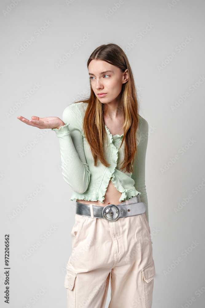Young Woman Pointing to copy space in studio Young Woman Pointing to copy space in studio