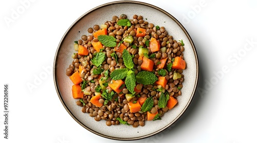 Colorful lentil salad with sweet potatoes, fresh herbs, and mint garnish on a ceramic plate