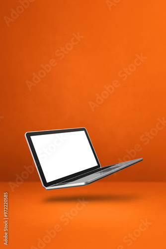 Naklejka Floating computer laptop isolated on orange. Vertical background