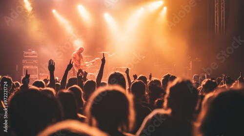 A lively concert scene with an audience enjoying a performance under bright lights.
