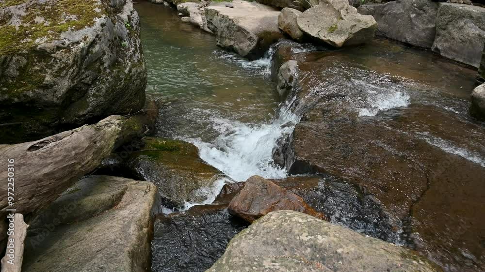 Small waterfall with water running over rocks Small waterfall with water running over rocks