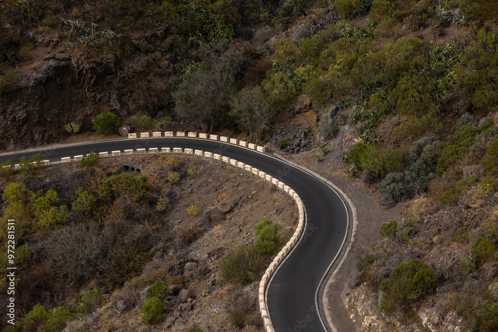 Fototapeta premium Mountain pass one-way curving road with cliffs on either side passing through the middle of the countryside.