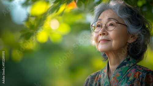 An elderly woman gazes serenely outdoors, surrounded by nature, embodying peace and contemplation in a lush green setting.