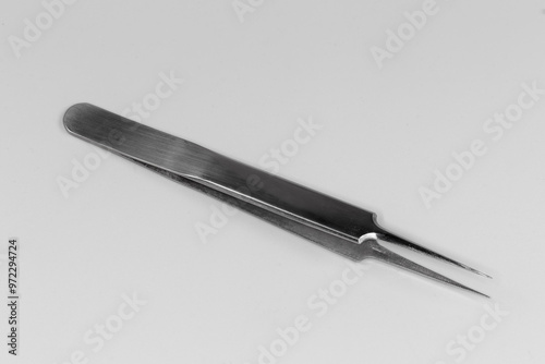 Steel tweezers with pointed tips on a gray background photo