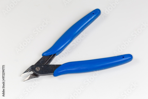 Diagonal nippers with blue insulated handles on a gray background photo