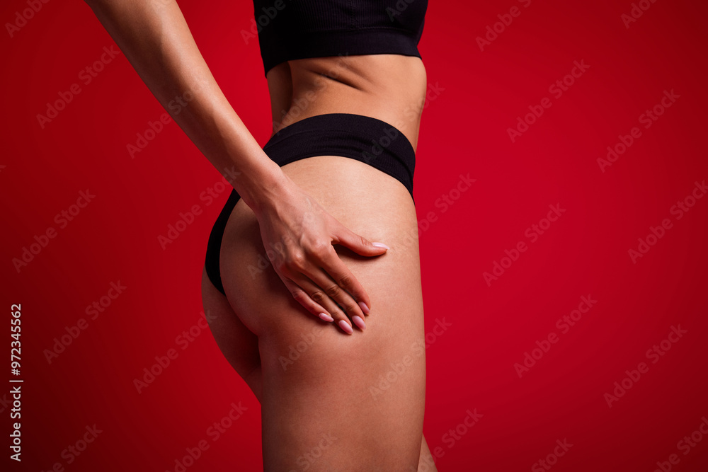 Fototapeta premium Cropped photo of lovely young lady touch booty skin cellulitis dressed black lingerie no filter isolated on red color background