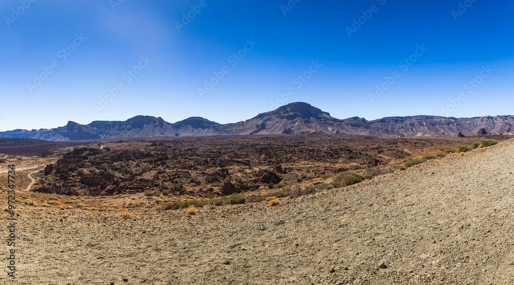 Panoramic view of desert landscape in arid desert with sandstones and large mountains in the background. Panoramic view of desert landscape in arid desert with sandstones and large mountains in the background.