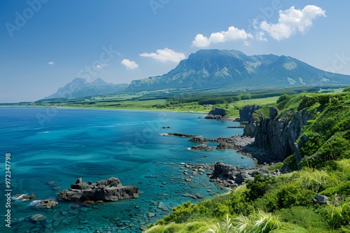 A breathtaking view of a rugged coastline with turquoise water and green mountains.