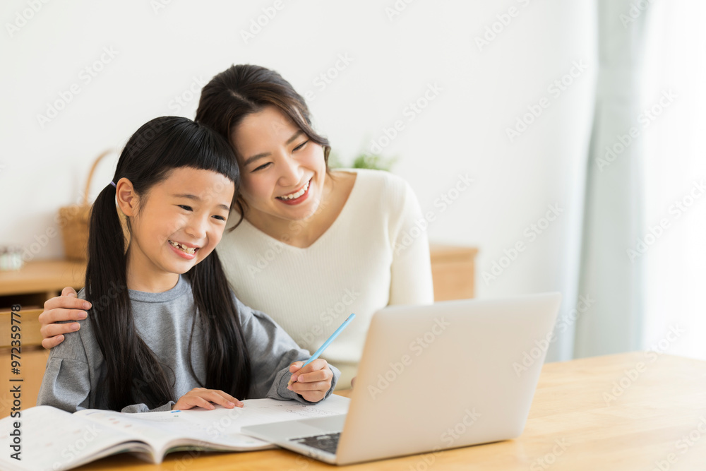 パソコンでオンライン学習をする女の子と母親