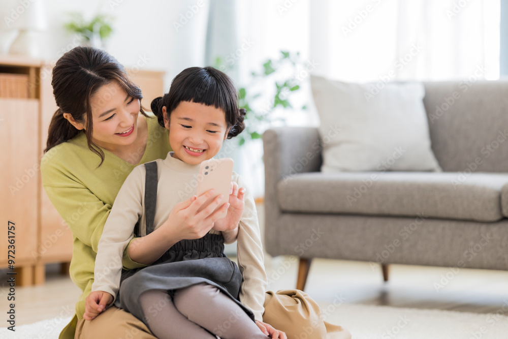 スマートフォンを見る親子 スマートフォンを見る親子