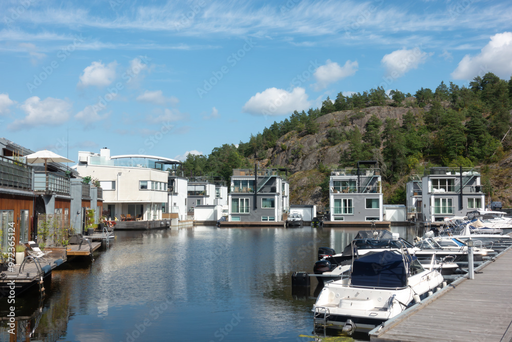 Marinstaden marina inspired locality in Nacka, Sweden, unique architecture with houses built on the water and boats moored Marinstaden marina inspired locality in Nacka, Sweden, unique architecture with houses built on the water and boats moored