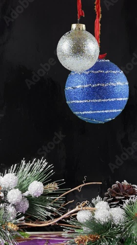 Christmas ornaments against black background with copy space, merry christmas and happy new year animated defocused lights background.