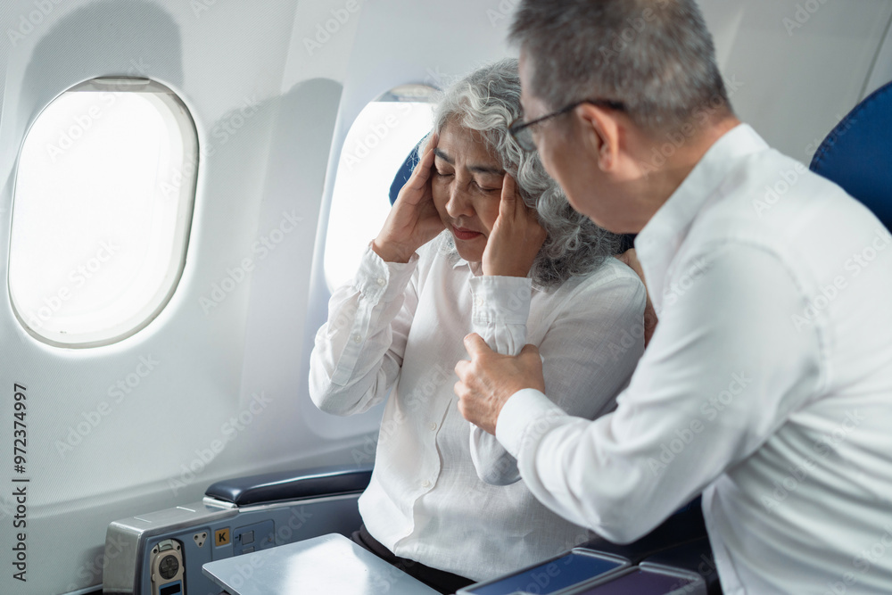 Mature with headache with nausea feeling sick while sitting in the airplane, Passengers near the window. Mature with headache with nausea feeling sick while sitting in the airplane, Passengers near the window.