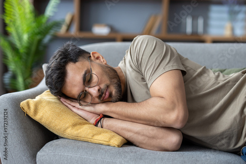 Photography Close-up photo of a young Indian man sleeping and relaxing on the couch at home