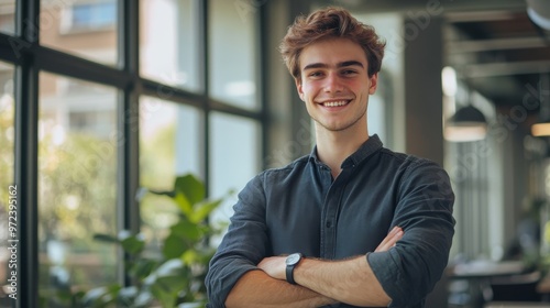 Confident Young Man in Modern Office Setting with Hands Resting on Desk