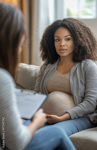 A Black pregnant woman talking to a female therapist.
