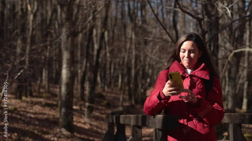 Cheerful hispanic woman in forest setting using cellphone and taking selfies. Copy space. Cheerful hispanic woman in forest setting using cellphone and taking selfies. Copy space.
