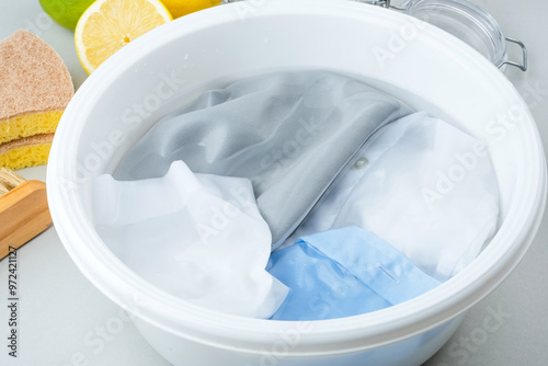 Bild auf Leinwand Soaking cosmetic stains on the colored fabric in a plastic basin of cold water