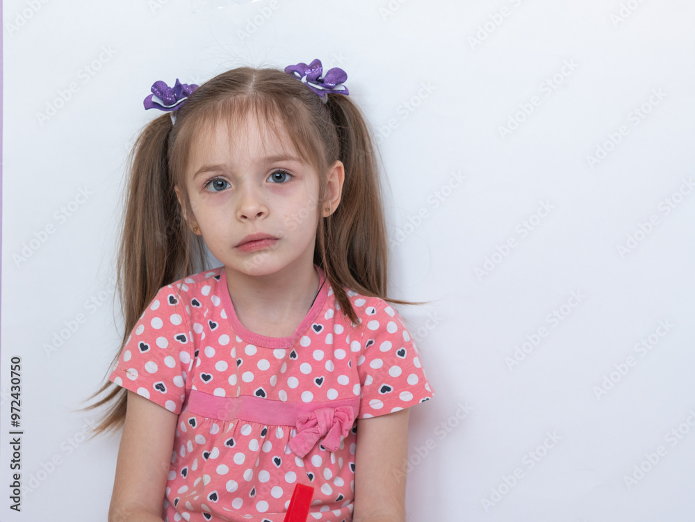 A thoughtful child. Portrait of a little girl with an innocent look on a white background. A place for the text A thoughtful child. Portrait of a little girl with an innocent look on a white background. A place for the text