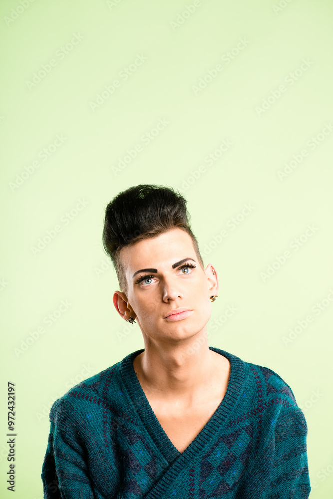 Gay, man and thinking of fashion for beauty, trendy makeup or skincare in studio on green background. Creative, cosmetics and ideas with lgbtq mockup space or identity crisis with aesthetic or pride Gay, man and thinking of fashion for beauty, trendy makeup or skincare in studio on green background. Creative, cosmetics and ideas with lgbtq mockup space or identity crisis with aesthetic or pride