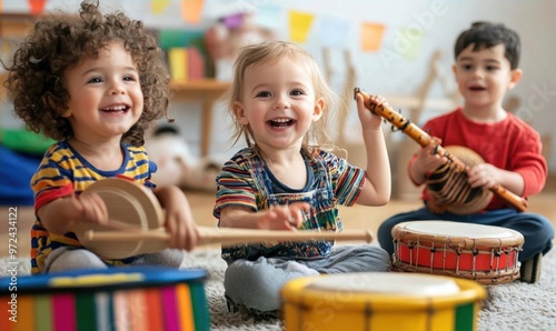 Three children playing music on drums, one boy playing a wooden flute and the other two playing hand drums, sitting on the floor.