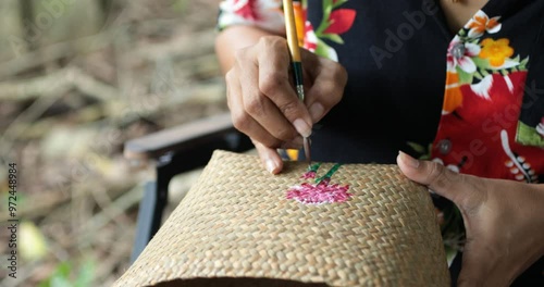 Hands of a Beautiful artist lady and artist painting together at a colorful table, surrounded by basket, brushes, acrylic colors tube and craft materials,Wicker handmade from krachut , Close up shot. photo