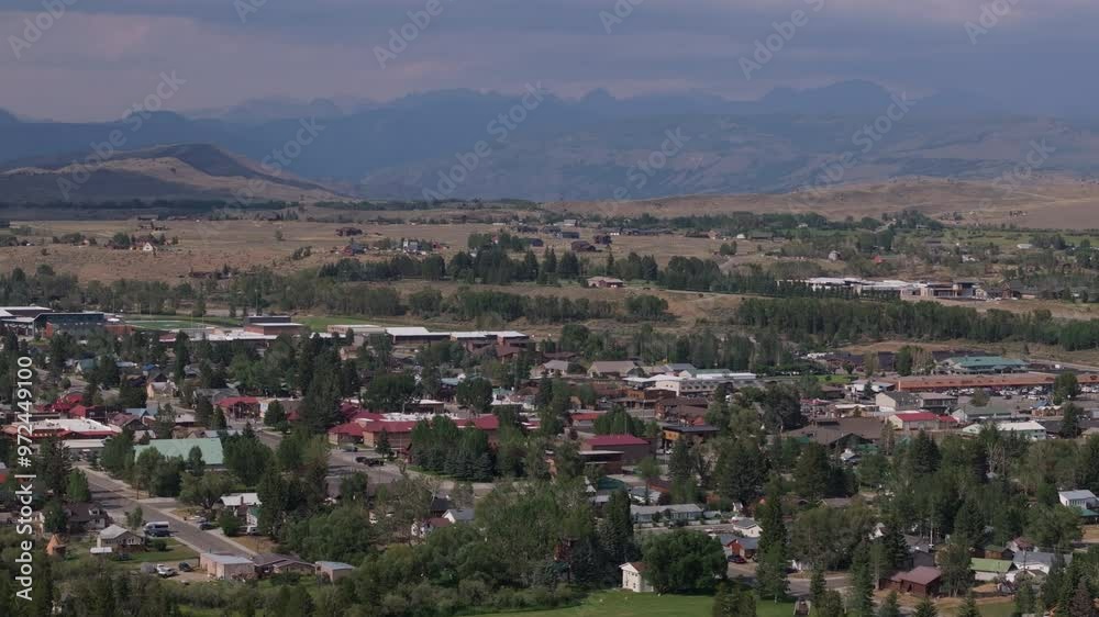 Small town nestled in a valley with mountains in the distance on a sunny day Small town nestled in a valley with mountains in the distance on a sunny day