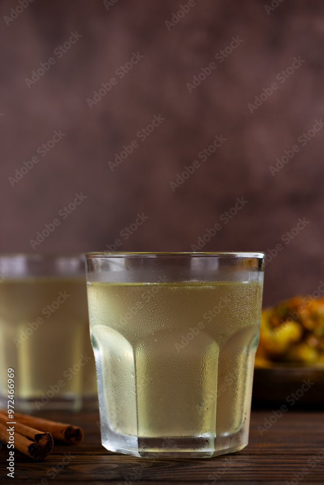 Tepache, popular Mexican fermented pineapple drink in a glasses. Chilled drink poured into glass. Fermented, probiotic drink. Vertical orientation. Tepache, popular Mexican fermented pineapple drink in a glasses. Chilled drink poured into glass. Fermented, probiotic drink. Vertical orientation.