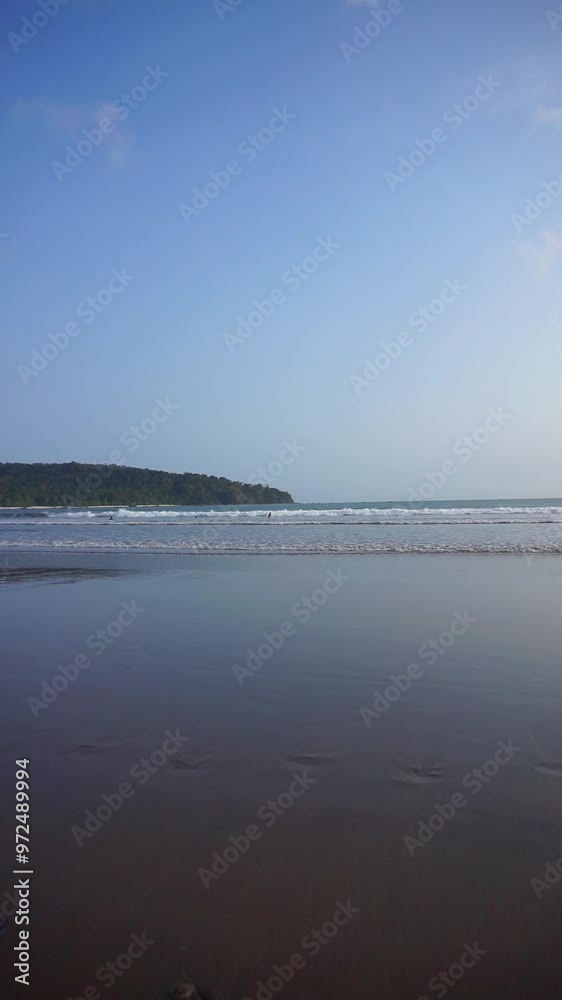 Beautiful vertical video of a beach scene, with waves during the day. Pangandaran Beach