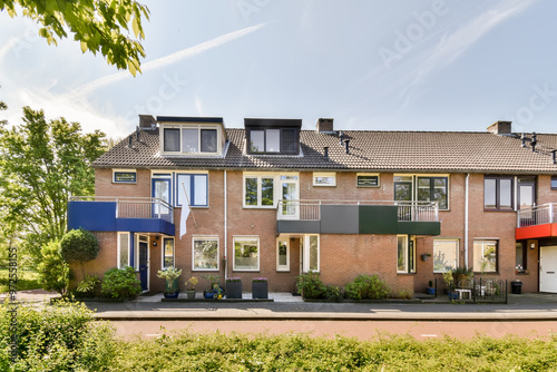Suburban townhouses with sunny facade and awnings