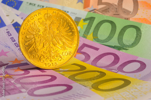 Eine Goldmünze steht auf einem Bündel Euro Banknoten photo