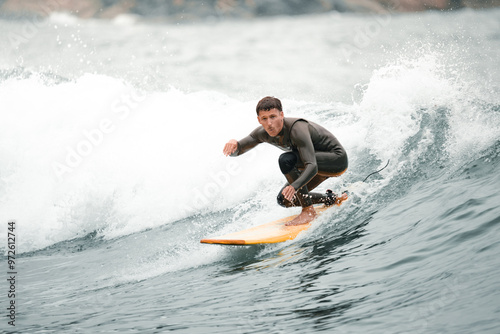     Surfers catching waves, waiting for a wave to come in the middle of the ocean near the beach during a beautiful day